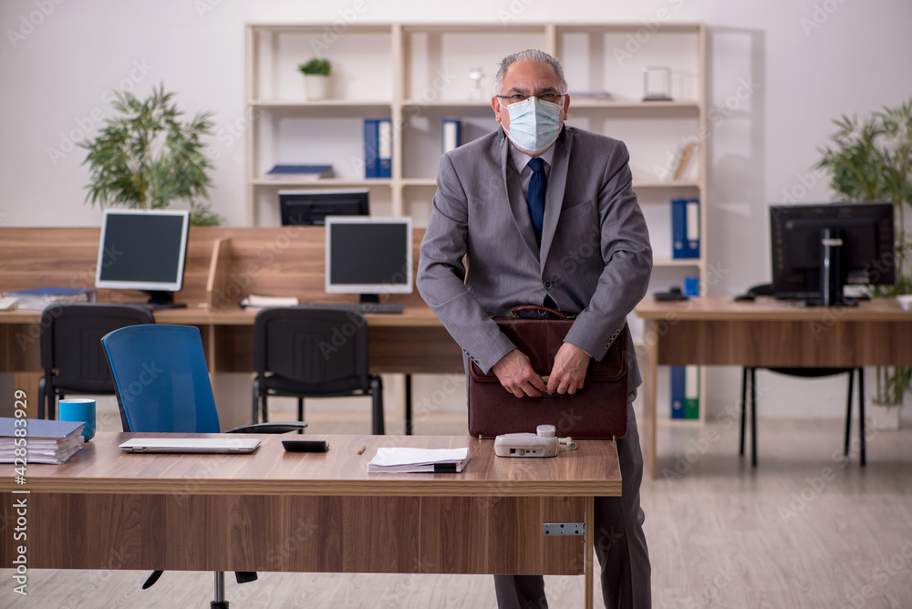 Coronavirus infected old businessman employee sitting in the off Coronavirus infected old businessman employee sitting in the off