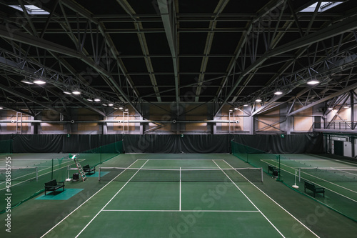 Empty green tennis courts under roof. Nobody. Top view.