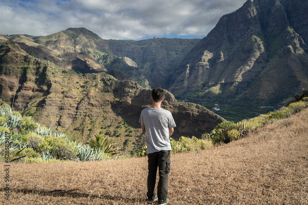 Obraz premium young man contemplates the landscape. Agaete valley. Gran Canaria