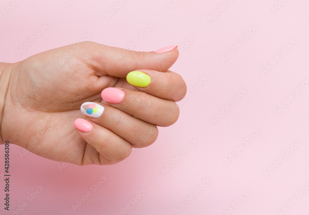 Female hand with summer manicure with ice cream on pink background Female hand with summer manicure with ice cream on pink background