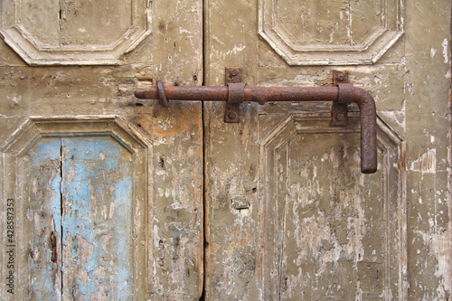 old iron, rusty latch on the old wooden door
