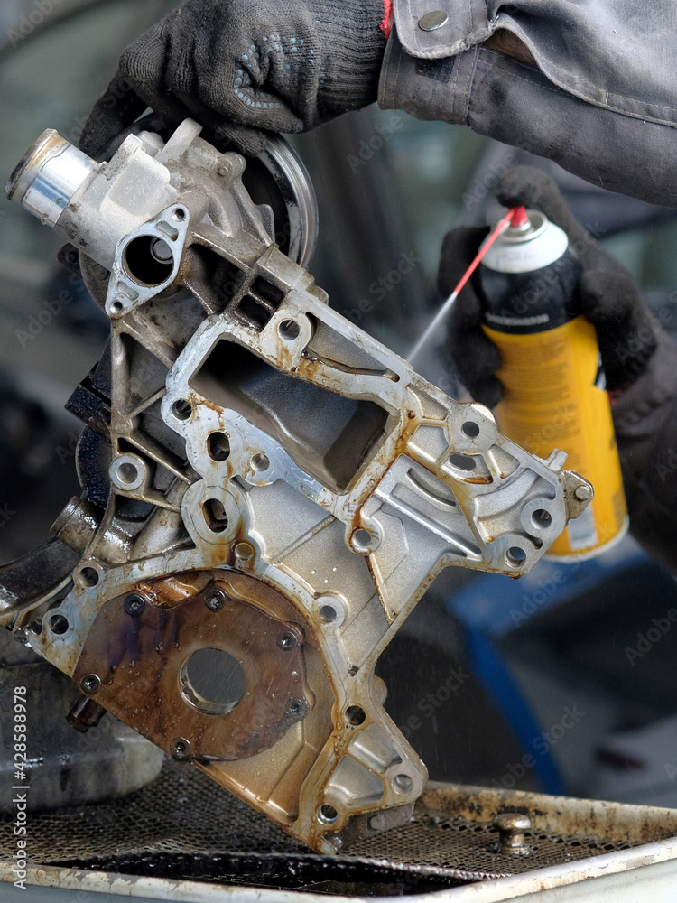 Fototapeta premium Repair of the internal combustion engine in the service center. Cleaning the front engine cover.