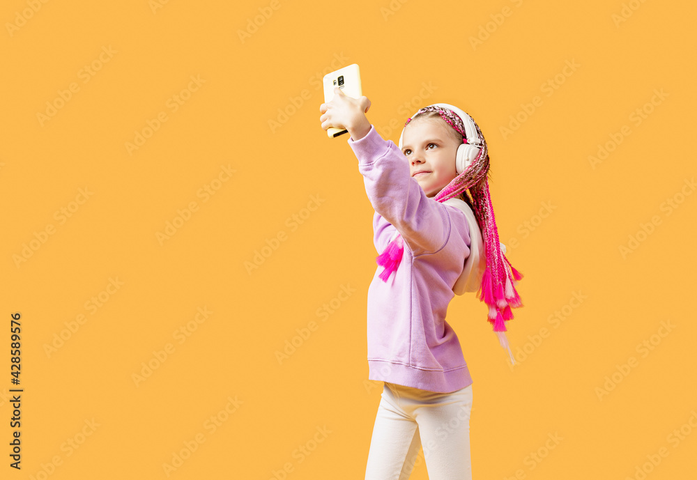 Pretty modern girl with pink dreadlocks in headphones smiling an Pretty modern girl with pink dreadlocks in headphones smiling an