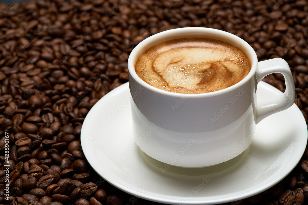 Cup of espresso coffee on Background made of roasted brown coffee beans Cup of espresso coffee on Background made of roasted brown coffee beans