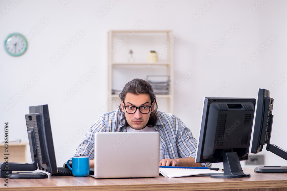 Young male it specialist working in the office Young male it specialist working in the office