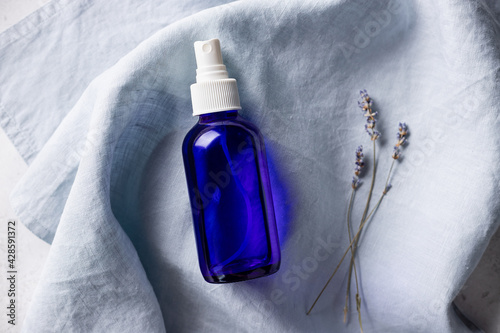 Foto lavender spray in blue glass bottle on linen towel