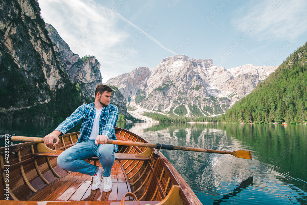 man rowing on boat at mountain lake