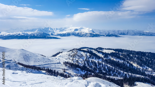 Snowy mountains on a sunny but foggy day. Beautiful winter panorama of the ski resort in Sochi, Russia © Elena Sviridova