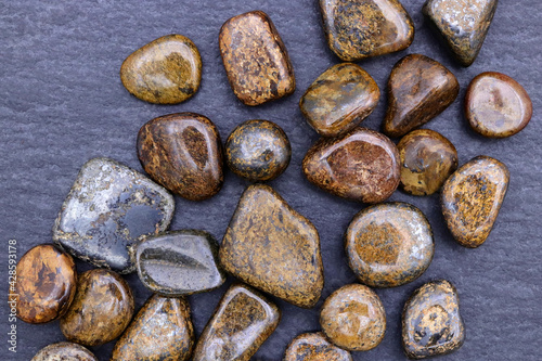 Bronzite heap up jewel stones texture on black stone background photo