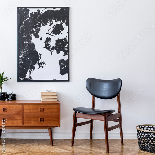 Fototapeta Naklejka Na Ścianę i Meble -  Stylish interior design of living room with wooden retro commode, chair, tropical plant in rattan pot, basket and elegant personal accessories. Mock up poster frame on the wall. Template. Home decor.