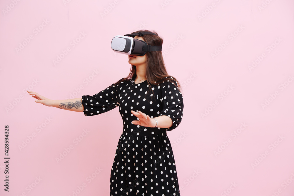 Funny woman in VR headset probing space around her with her hands.
