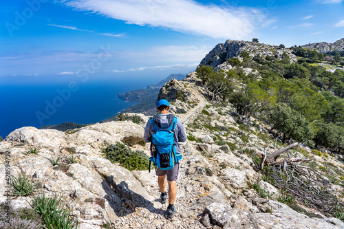 Schönes Mallorca: Wanderung einer Gruppe im Naturpark über Valldemossa auf dem historischen Reitweg des Erzherzogs Salvator auf den Caragoli - Mann genießt den Ausblick auf dem Grat photo