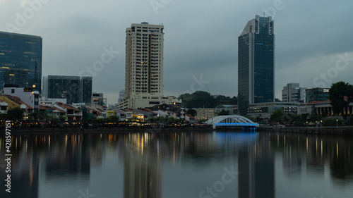 A scene at Boat Quay  Singapore  during sunset with long exposure and reflection of the skyline on the Singapore River