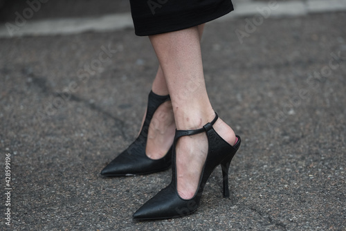 Detail of a fashionable outfit – detail of a girl wearing elegant black carving shoes