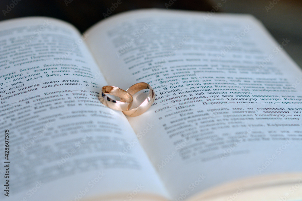 Fototapeta premium wedding rings on the book with a text