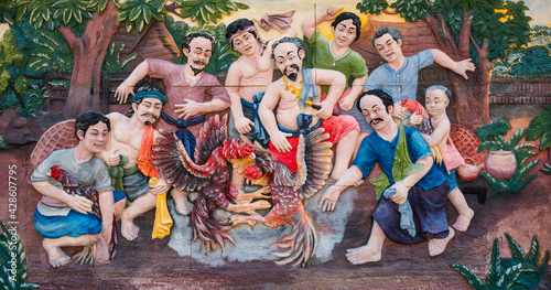 Bild auf Leinwand Stone carving of traditional Thai culture rural cockfighting on temple wall