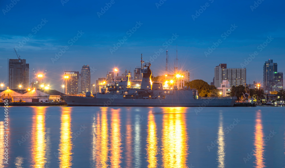 Warship docked at the port of Bangkok in the evening.