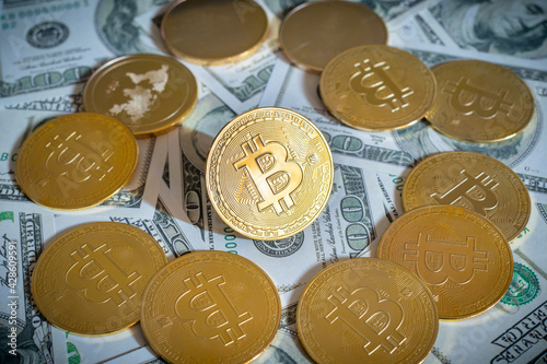 Bitcoin cryptocurrency coin and dollar bill in background