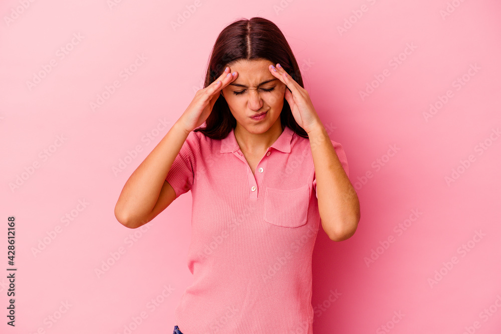 Young Indian woman isolated on pink background having a head ache, touching front of the face. Young Indian woman isolated on pink background having a head ache, touching front of the face.