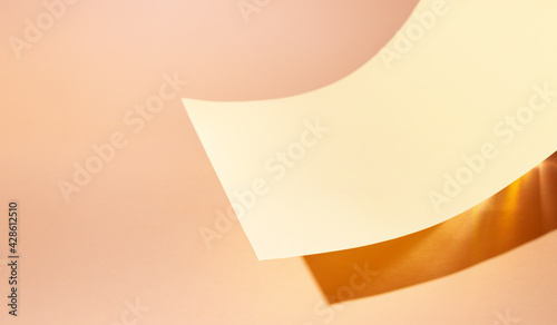 Abstract creative background with paper podium. Mock up for branding and packaging presentation. Podium of curve shaped beige color paper with lighting at the bottom.