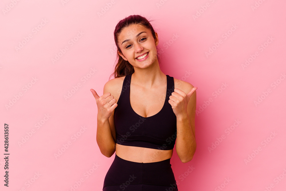 Young sport Indian woman isolated on pink background raising both thumbs up, smiling and confident. Young sport Indian woman isolated on pink background raising both thumbs up, smiling and confident.