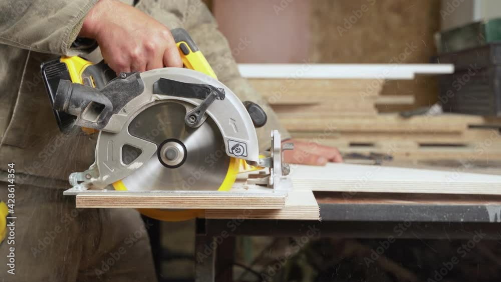Woodcutter cuts planks with a circular saw Woodcutter cuts planks with a circular saw