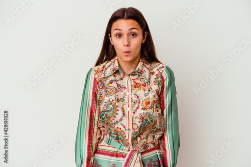 Young Indian woman isolated on white background shrugs shoulders and open eyes confused.