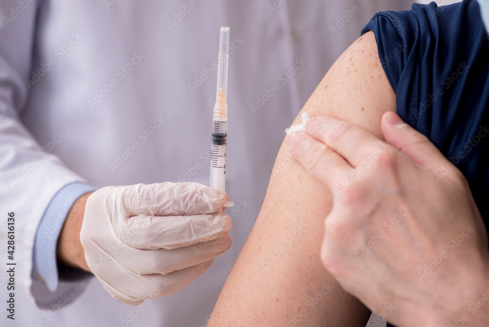 Old male patient visiting young male doctor in vaccination conce Old male patient visiting young male doctor in vaccination conce