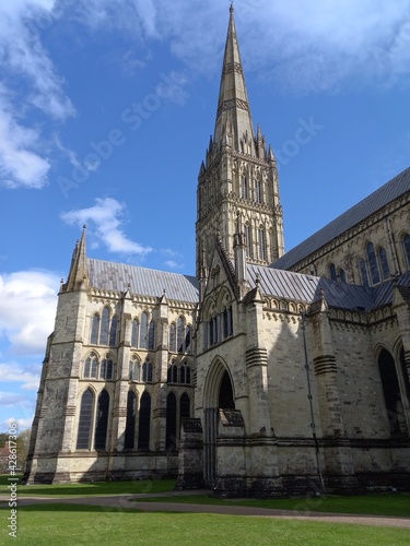 The Anglican cathedral of Salisbury in Wiltshire against a blue sky, including the tower and spire and showcasing the Gothic architecture.