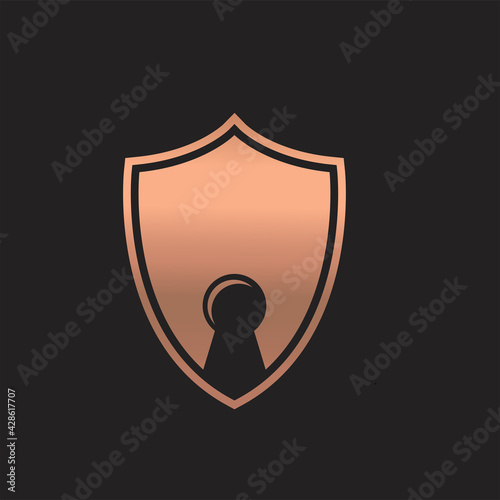 Metallic golden abstract key hole logo concept vector. A bronze shield with keyhole logo