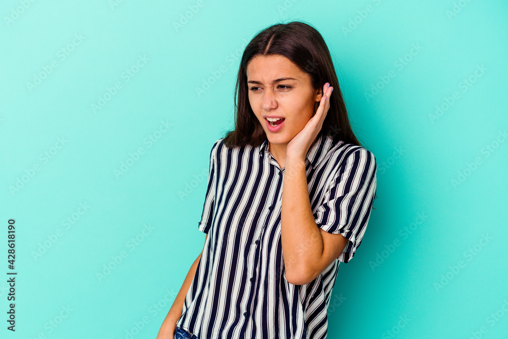 Young Indian woman isolated on blue background trying to listening a gossip. Young Indian woman isolated on blue background trying to listening a gossip.