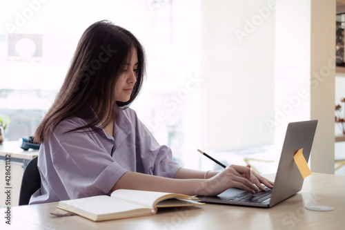 Online education. Asian girl online lesson using a computer video call to a virtual teacher at home