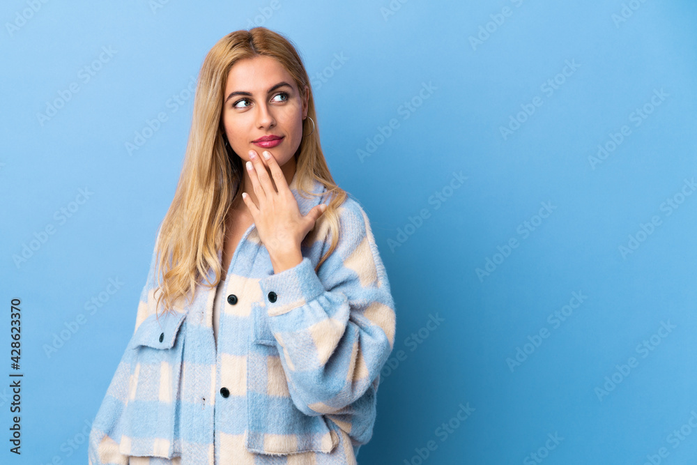 Young Uruguayan blonde woman over isolated background looking up while smiling Young Uruguayan blonde woman over isolated background looking up while smiling