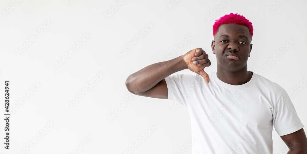 Fototapeta premium Refusing man. Dislike gesture. Bad choice. Looser blaming. Skeptic emotion. Stylish disgusted african guy with bright pink hair showing disapproval sign isolated white copy space.
