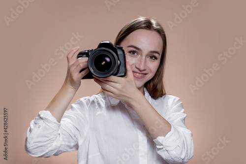 Young happy girl takin pictures with digital camera. Work, people, hobby, lifestyle, technology, studying concept