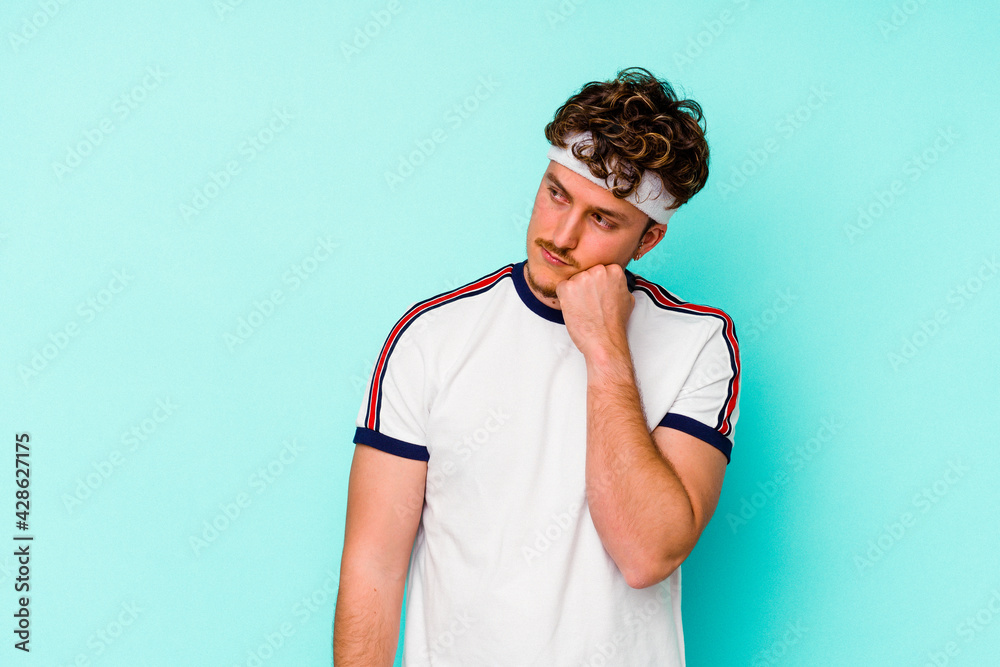 Young sport caucasian man isolated on blue background who feels sad and pensive, looking at copy space. Young sport caucasian man isolated on blue background who feels sad and pensive, looking at copy space.