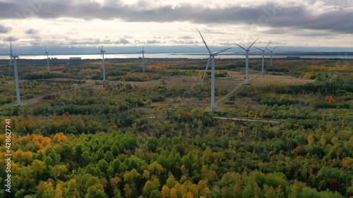 The Windmills park of Paldiski. Wind turbine farm near Baltic sea. Autumn landscape with windmills, orange forest and blue sky. Pakri peninsula, Estonia, Europe