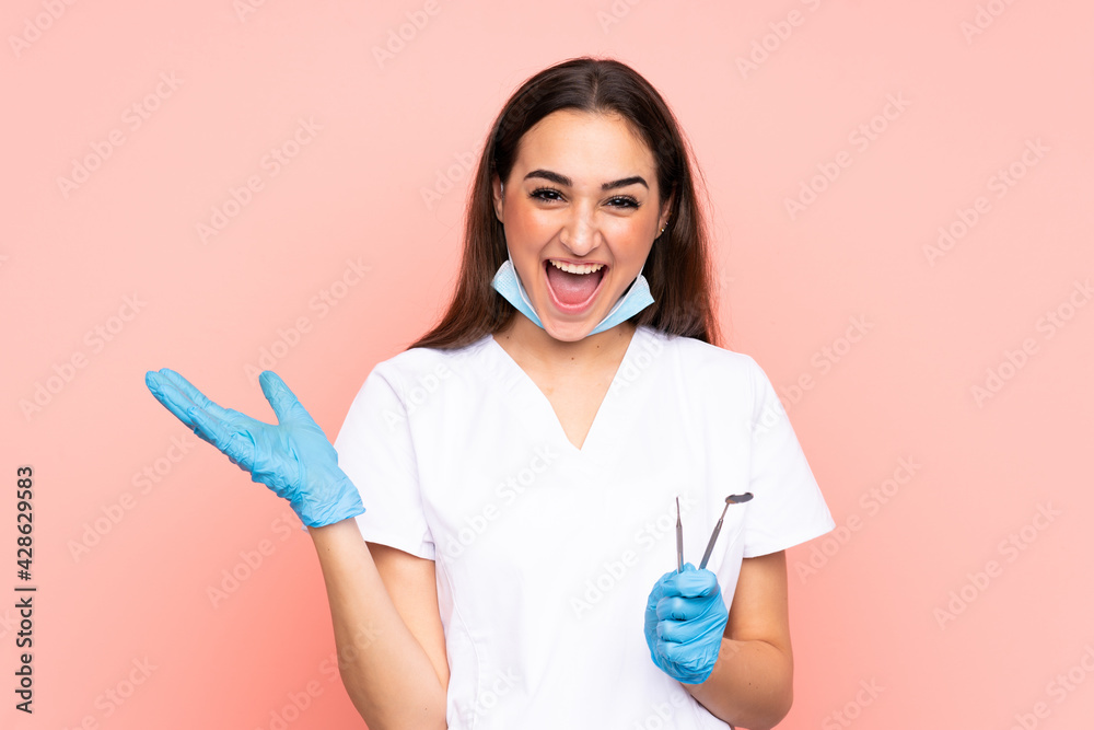 Woman dentist holding tools isolated on pink background unhappy and frustrated with something Woman dentist holding tools isolated on pink background unhappy and frustrated with something