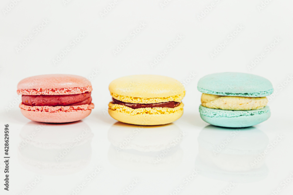 Sweet almond colorful pastel pink blue yellow macaron or macaroon dessert cake isolated on white background. French sweet cookie. Minimal food bakery concept Copy space