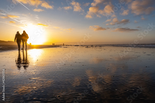 Spaziergänger bei Sonnenuntergang am Strand der Nordseeinsel Langeoog © bilderstoeckchen