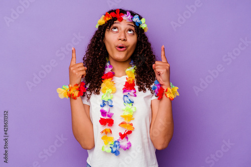 Young Hawaiian woman isolated on purple background pointing upside with opened mouth.