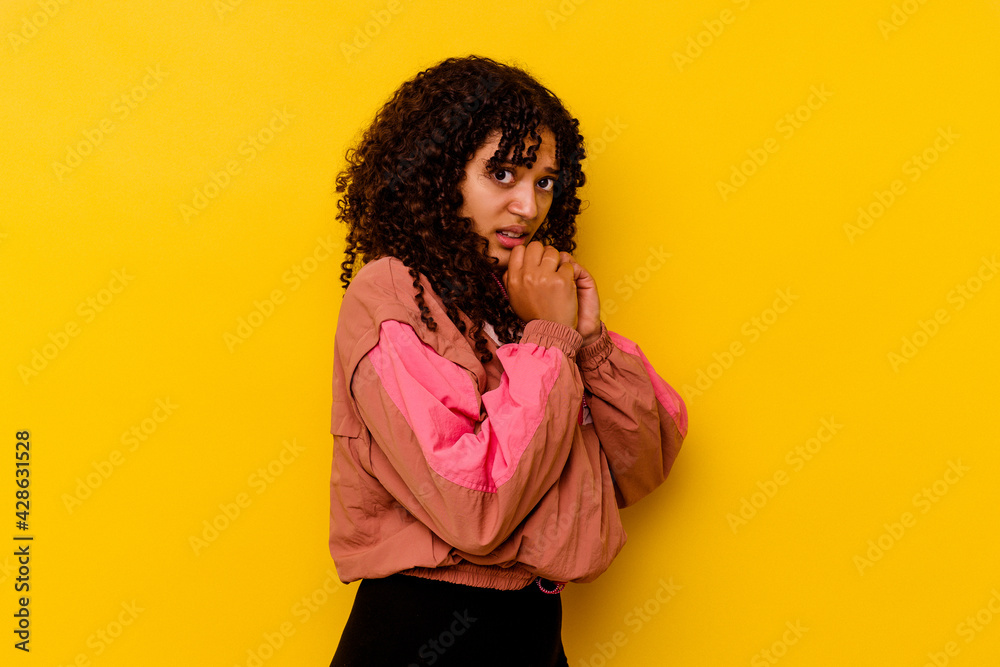 Young mixed race woman isolated on pink background scared and afraid.