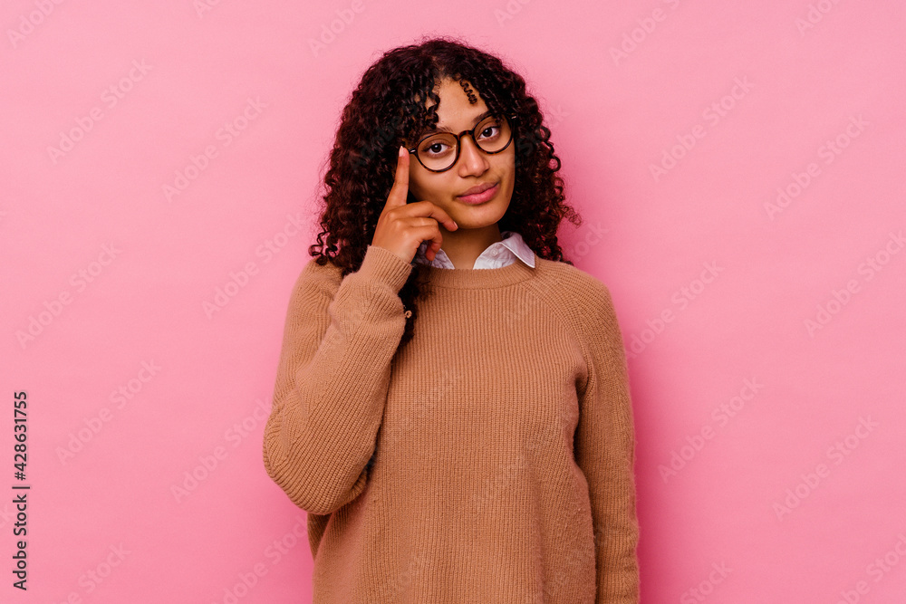 Young mixed race woman isolated on pink background pointing temple with finger, thinking, focused on a task. Young mixed race woman isolated on pink background pointing temple with finger, thinking, focused on a task.