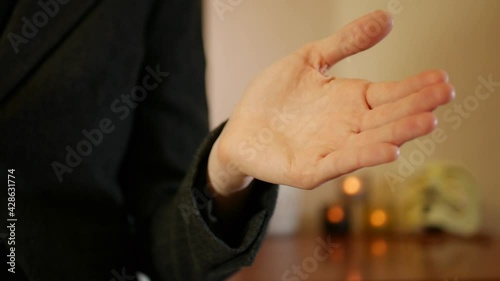 A woman impatiently pats her hand with a riding crop