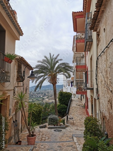 Finestrat, Alicante, Spain Narrow street in the old town with colored houses with shabby plaster and cobblestone stairs. © Jose Prieto