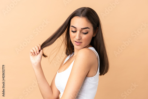 Young caucasian woman isolated on beige background . Portrait