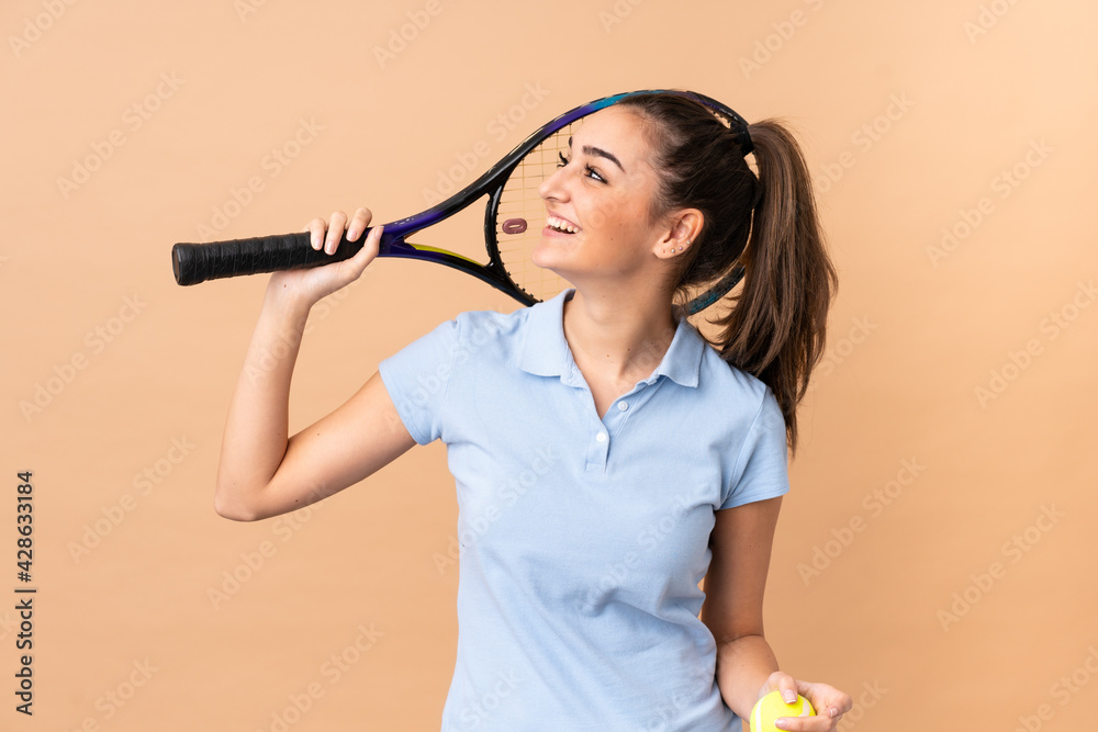 Young woman tennis player over isolated wall Young woman tennis player over isolated wall