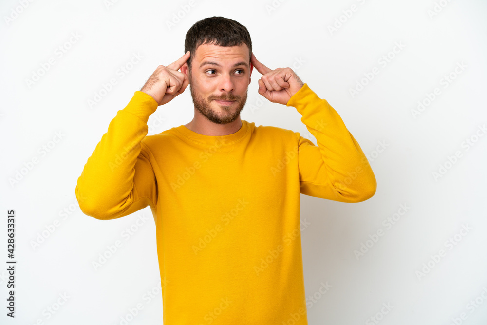 Young Brazilian man isolated on white background having doubts and thinking Young Brazilian man isolated on white background having doubts and thinking