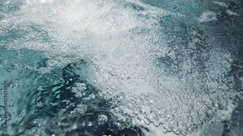 Close up, air bubbles from jacuzzi spa jet in swimming pool.