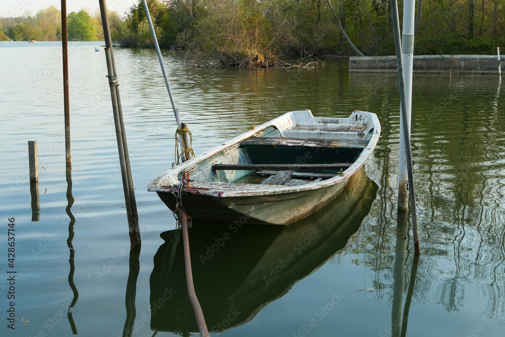 Abandoned rowing boat, isolated on a lake. Rowboat on water.